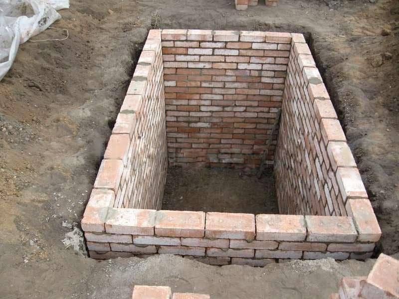 Для кладки кирпичных стены в погребе используют красный кирпич. Между стеной и обваловкой должен быть зазор для глиняного замка – слоя уплотненной глины, уложенной по контору подземной части стены .