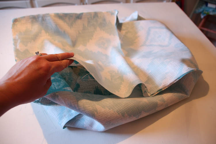 Folding the fabric together after being sewn.